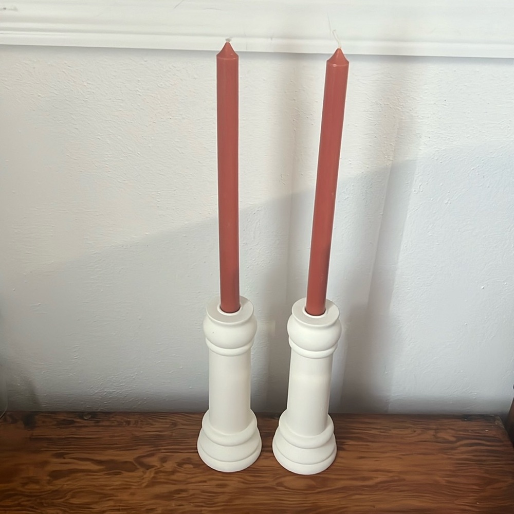 Pair of matching candlestick holders with rust/orange unlit candles